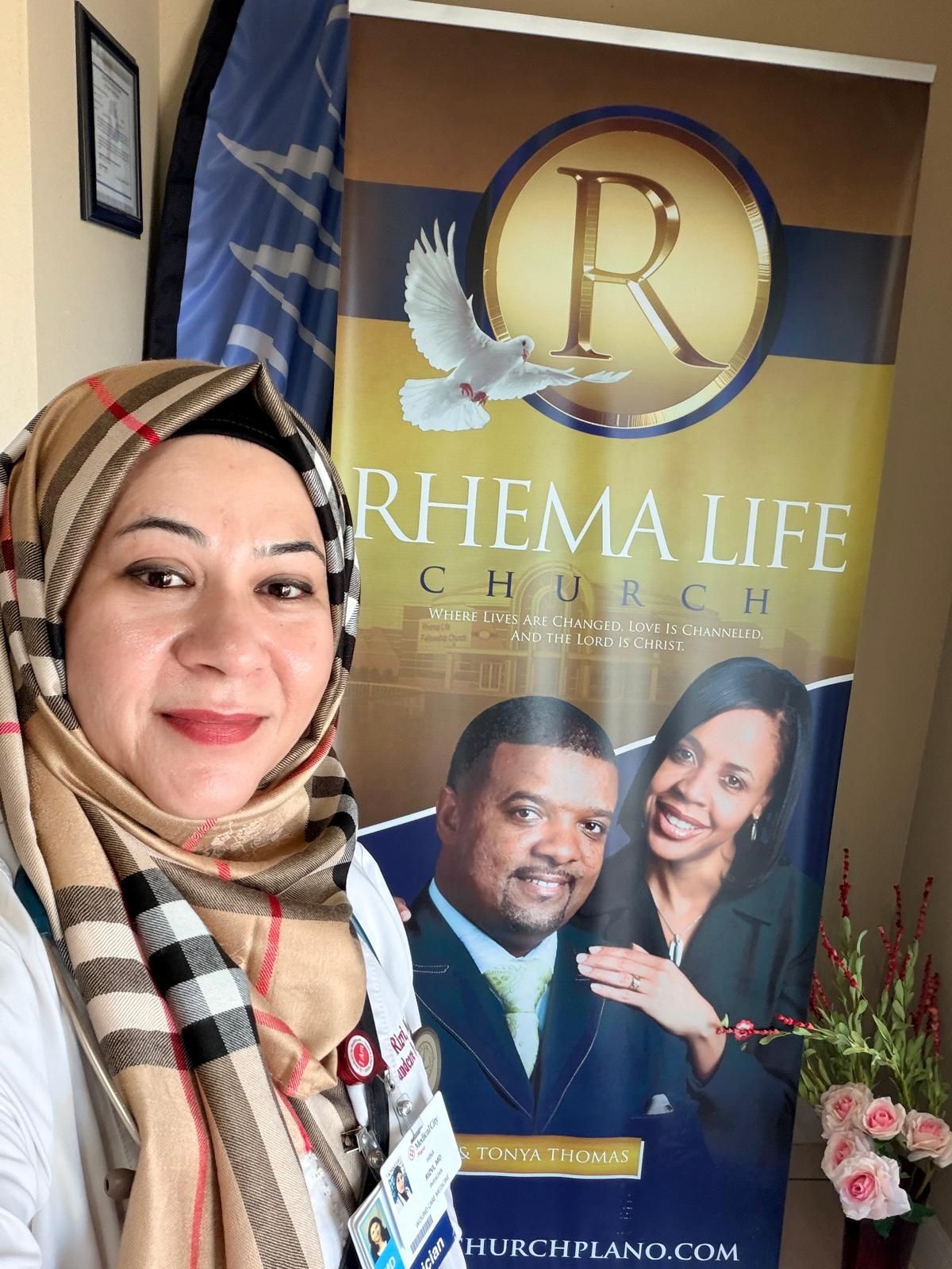 Dr. Rizvi in front of the Rhema Life Church banner featuring Pastor James and Tonya Thomas