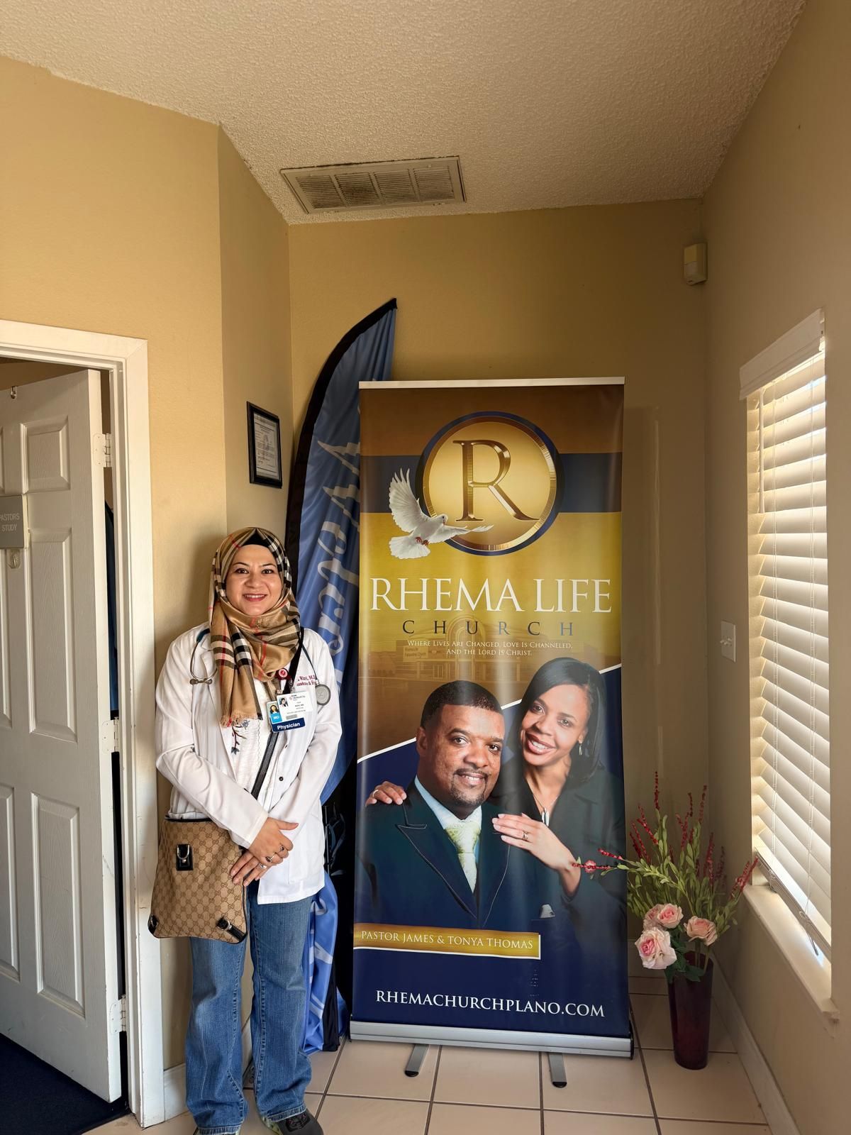 Dr. Rizvi beside the Rhema Life Church banner in Plano
