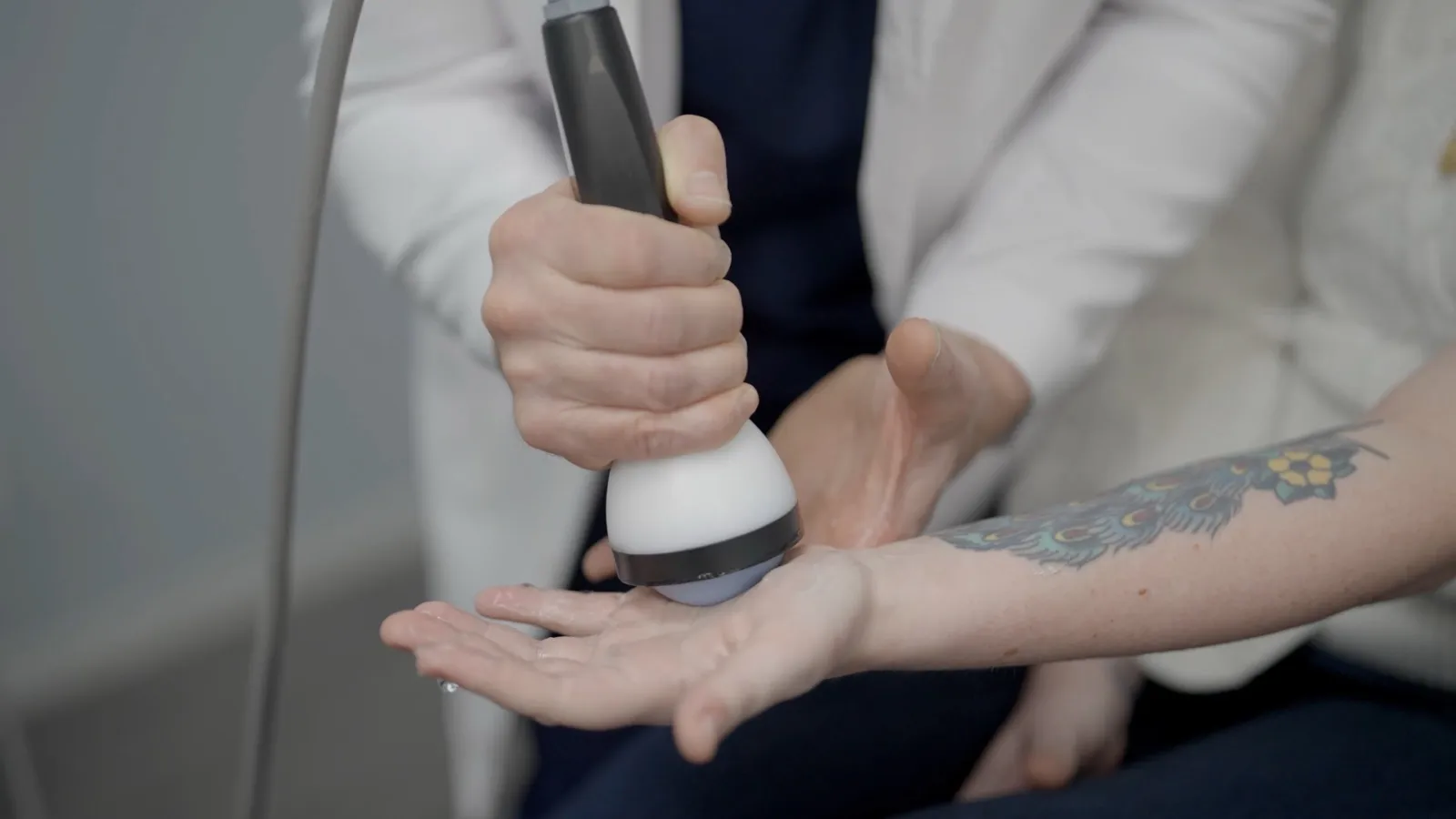 StemWave applicator delivering focused acoustic waves to a patient's wrist